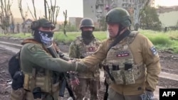 瓦格纳集团雇佣军首领普里戈津(右)在巴赫穆特与雇佣军士兵在一起。(2023年5月25日)