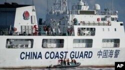 2023年4月23日,一艘中国海警船在南中国海有争议海域拦截菲律宾的海岸警卫队巡逻船,中国船员下到一艘马达船监视菲律宾海警船。