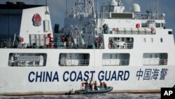 2023年4月23日,一艘中国海警船在南中国海有争议海域拦截菲律宾的海岸警卫队巡逻船,中国船员下到一艘马达船监视菲律宾海警船。