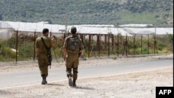 2022年4月13日,以色列士兵在以色列中部Ibthan附近的安全围栏旁巡逻,该围栏将以色列与被占领的约旦河西岸隔开。
