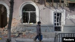 资料照片:当地居民走在乌克兰前线城镇巴赫穆特的空荡街道上。(2023年2月24日)