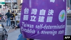 资料照:支持台湾独立的活动人士在台北西門町街头树起“台湾自决独立建国”旗子。(2024年2月3日)