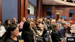 美国芬太尼危机受害者家属在国会众议院中共问题特设委员会针对芬太尼泛滥问题召开的听证会上手拿家人的照片聆听会议内容。(2024年4月16日,美国之音记者李逸华摄)