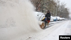 一名工人在北京街头扫雪。(2023年12月14日)