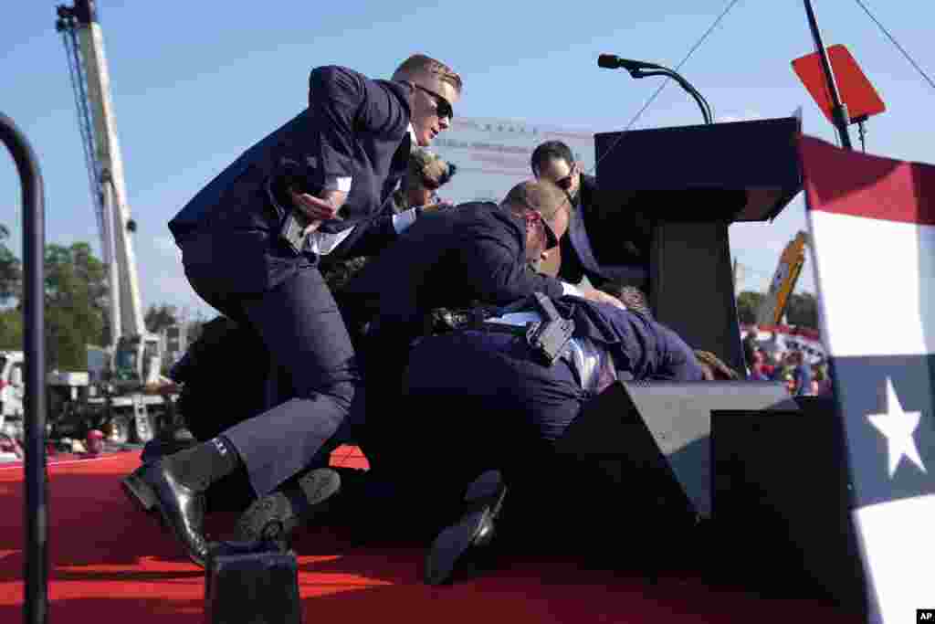 共和党总统候选人、前总统唐纳德·特朗普在枪击事件后被特勤局特工们保护