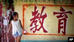 资料照:北京东坝一所农民工子女学校的墙上刷有“教育”的字样。(2011年8月23日)