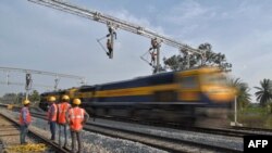 印度铁路公司的合同工在班加罗尔郊区架设用于在铁轨上牵引电缆线供机车使用的设施。(资料照片,2021年1月15 日)