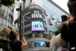 Sebuah layar digital di Seoul, Korea Selatan menampilkan gambar personil band K-pop BTS merayakan ulang tahun ke-10 grup kebanggan negara itu, Selasa, 13 Juni 2023. (AP/Ahn Young-joon)