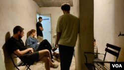 10月16日特拉维夫市中心, 警报声响起后,住在公寓楼的人们躲进楼底掩体里躲避火箭弹 (美国之音/唐丹鸿)