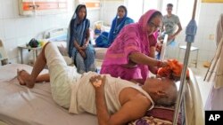 一名妇女在印度北方邦的一所医院里用湿布擦拭她生病的兄弟的头部,让他在热浪中保持凉爽。(2023年6月19日)