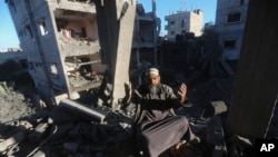 2023年12月15日,一名巴勒斯坦人在以色列袭击加沙地带拉法的住宅楼后作出反应。(美联社照片)