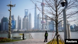 资料照:一名保安在上海浦东陆家嘴金融区对岸公园里执勤(2023年3月7日)