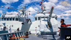 资料照片:在柬埔寨金边的云朗海军基地,柬埔寨海军官兵站在一艘巡逻艇上。(2023年12月3日)