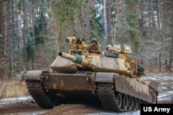 资料照片:美军在波兰贝莫沃·皮斯基的一次演练期间驾驶M1A1艾布拉姆斯坦克。(2022年11月25日)