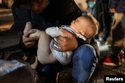 一位来自中国的爷爷抱着三个月大的孙子穿越美墨边界进入德州。(2023年4月1日)