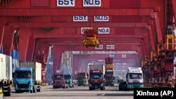 集装箱船正在中国山东省青岛港进行卸载。(2024年2月11日)