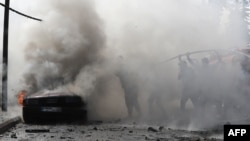 以色列袭击黎巴嫩南部城市西顿后,黎巴嫩消防队员在扑灭一辆汽车的大火。(2024年8月21日)