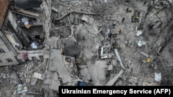 2024年3月25日,救援人员在乌克兰基辅一处遭到导弹袭击的现场展开工作。(法新社照片)