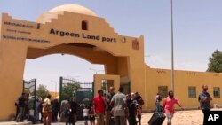 2023 年 4 月 27 日,在埃及和苏丹之间的国际边界线上,为逃离冲突从苏丹撤离后,撤离人员携带行李通过 Argeen 陆路口岸进入埃及。