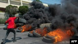 waandamanaji wakichoma moto mataili huko Port-au-Prince Machi 12, 2024. Picha na AFP