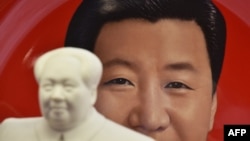 资料照:北京天安门附近一个纪念品商店里毛泽东的塑像摆在习近平纪念画盘的前面。(2018年2月27日)