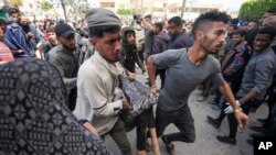 巴勒斯坦人在以色列袭击加沙阿克萨医院后抬走伤员。(2024年3月31日)