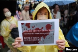 台湾民众聚集在台北的立法院外,一名女子手举表达自己政治意愿的标语牌。(2024年5月24日)