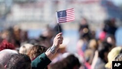 资料照片:2023年2月15日,人们在加利福尼亚州圣地亚哥举行的入籍仪式上朗读宣誓词。(美联社照片)