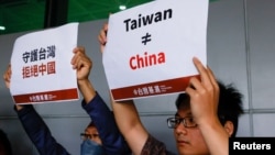 资料照:支持台湾独立的人士在台北桃园国际机场举牌抗议台湾前总统马英九前往中国大陆的旅行。(2023年4月7日)