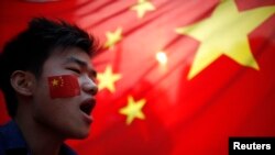 资料照:示威者在上海举国旗抗议日本侵华战争爆发81周年。(2012年9月18日)