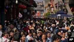 2023年5月1日,北京前门步行街游客摩肩接踵,人山人海。这是新冠病毒大流行之后,人们第一次在没有严厉的防范措施中过节。