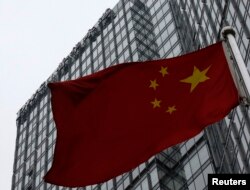 资料照:一面中国国旗在普华永道在北京的办公楼前飘扬。(2024年1月24日)