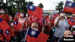 资料照:台湾老兵之家的老兵和护工挥舞台湾旗帜庆祝双十节。(2023年10月10日)