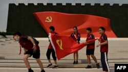 资料照:中国学生在北京中共历史展览馆内拉起一面中共党旗拍照。(2022年9月4日)