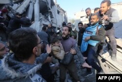 Seorang pria Palestina mengevakuasi seorang gadis yang terluka dari lokasi serangan Israel di daerah Zawayda di Jalur Gaza tengah pada 30 Desember 2023. (Foto: AFP)