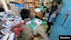 UNRWA ကုလစားနပ်ရိက္ခာဖြန့်ဖြူးရေးအေဂျင်စီကို အစ္စရေးတိုက်ခိုက်မှုအပြီး မြင်ရတဲ့ သွေးစွန်းနေတဲ့ အကူအညီပေးရေးရိက္ခာထုတ်တွေနဲ့ ပါလက်စတိုင်း အလုပ်သမားတဦး။ (မတ်လ ၁၃၊ ၂၀၂၄)