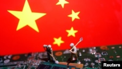 资料照:以中国国旗为背景的工人和半导体芯片图示。