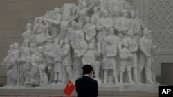 一名参观者在北京的中国共产党历史展览馆里手持一面中共党旗。(2022年10月12日)