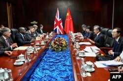 中国外长王毅(右二)与英国外相拉米(David Lammy)在老挝万象出席东盟外长会议期间举行会谈。(2024年7月26日)