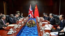 2024年7月26日,中国外长王毅(右二)与英国外相拉米在老挝万象出席东盟外长会议期间举行会谈。(法新社照片)