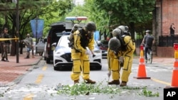 在韩国首尔,身穿防护装备的韩国军人正在检查疑似由朝鲜发送的气球残骸。(2024年7月24日)