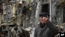 A man takes a video of a damaged restaurant after Russian shelling hit in Zaporizhzhia, Ukraine, March 18, 2023.