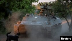 资料照片：乌军第93机械化旅的军人在巴赫穆特附近前线驾驶一辆配备高射炮的装甲车。(2024年5月23日) 