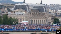 2024年7月26日,法国巴黎2024年夏季奥运会开幕式前,游客们聚集在一座桥上。(美联社照片)