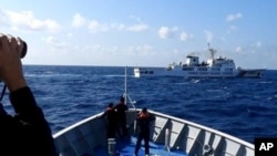 资料照:菲律宾海岸警卫队发布照片显示,一艘中国海警船(上)正在有争议的南中国海阻拦一艘菲律宾政府船只登陆铁线礁(Sandy Cay )。(2024年3月21日)