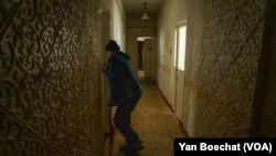 一位在康斯坦丁尼夫卡的庇护所栖身的前巴赫穆特居民试图打开她暂时为家的房门。(2023年4月11日,美国之音博夏特拍摄)