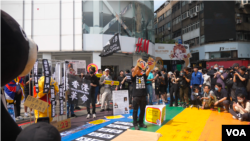 在台流亡港人与香港青年团体等2024年3月23日于台北发起街头集会,以穿插行动剧的方式,谴责当日生效的香港《基本法》第23条 (美国之音特约记者黄丽玲拍摄)。