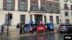 维吾尔抗议者在伦敦的雨中高举标语,纪念七五事件15周年 (美国之音/李伯安)