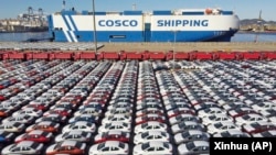 资料照:中国山东烟台港口排列着即将出口的汽车。(2021年12月7日)