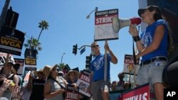 资料照片:演员兼电影制片人贾斯汀·贝特曼(右)2023年7月13日在洛杉矶举行的作家协会集会上对使用人工智能模型制作电影和电视的方式感到不安,认为这种方式可能会破坏电影业的结构并取代其大部分人力。 (美联社照片)